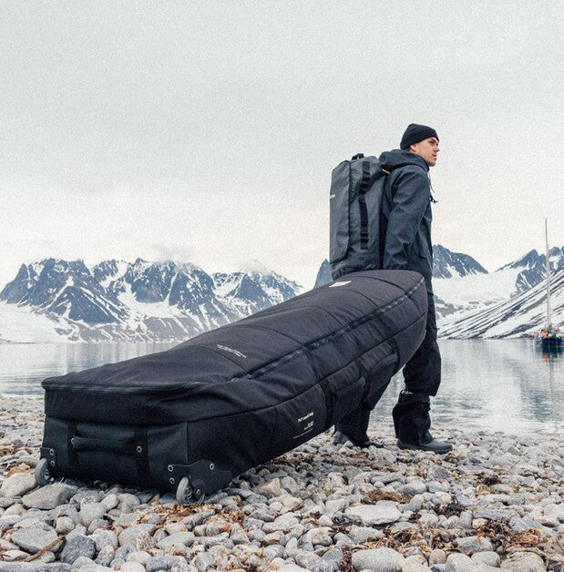 Surfer mit 747 Travelbag am Strand