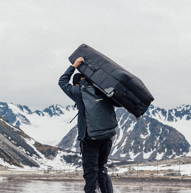 Surfer trägt 747 Travelbag auf den Schultern über den Strand