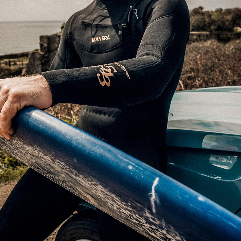 Detailansicht vom Print auf dem Ärmel. Surfer hätt Board auf dem Schoss.